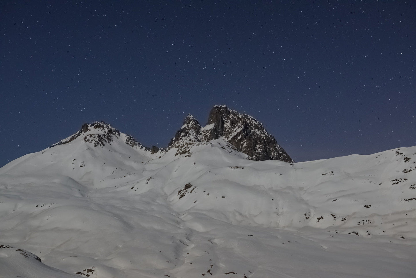 The Pic du Midi d'Ossau and the Pourtalet covered in snow under a starry sky, Pyrenees, Ossau Valley. - Photo to download